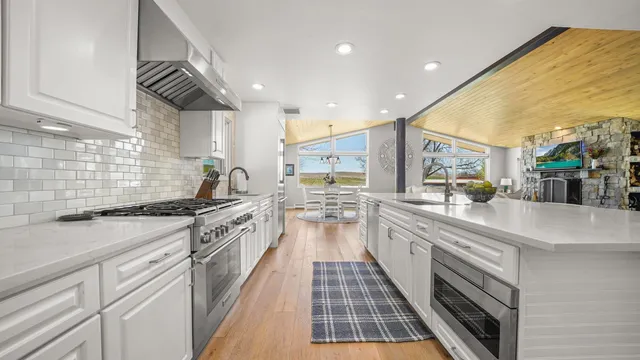 a large kitchen with stainless steel appliances granite countertop a lot of counter space and a sink