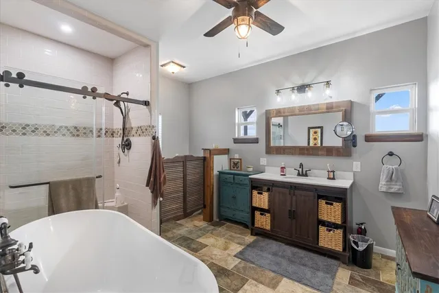 a spacious bathroom with a tub sink and mirror