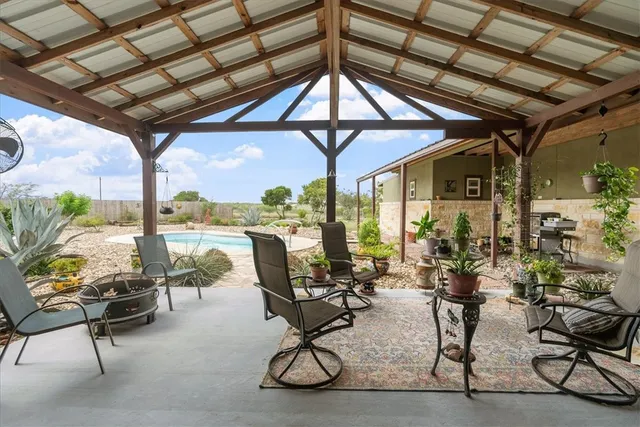 a view of a patio with table and chairs and potted plants