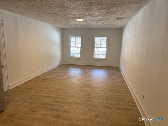 667 South Britain Road, Unit A Southbury, CT 06488 - Photo 2 of 8 an empty room with wooden floor and windows