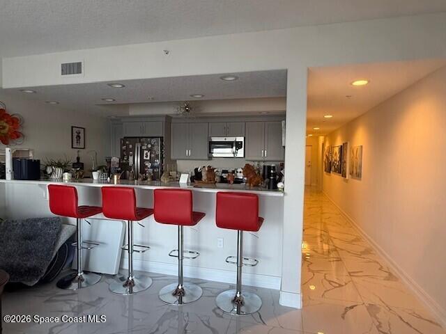 1805 Riverside Drive, Unit 404 Titusville, FL 32780 - Photo 12 of 19 a kitchen with stainless steel appliances kitchen island granite countertop a refrigerator and chairs