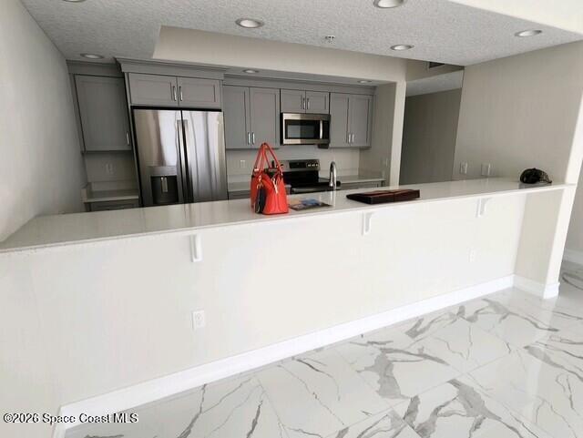 1805 Riverside Drive, Unit 404 Titusville, FL 32780 - Photo 14 of 19 a kitchen with stainless steel appliances a refrigerator sink and microwave