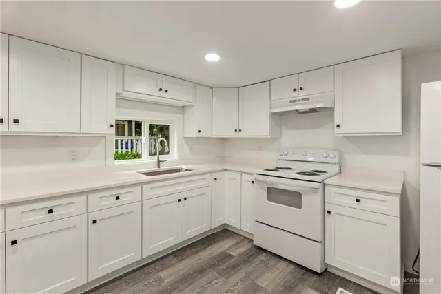 a kitchen with white cabinets and white appliances