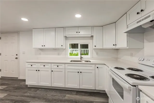 a kitchen with white cabinets and white appliances