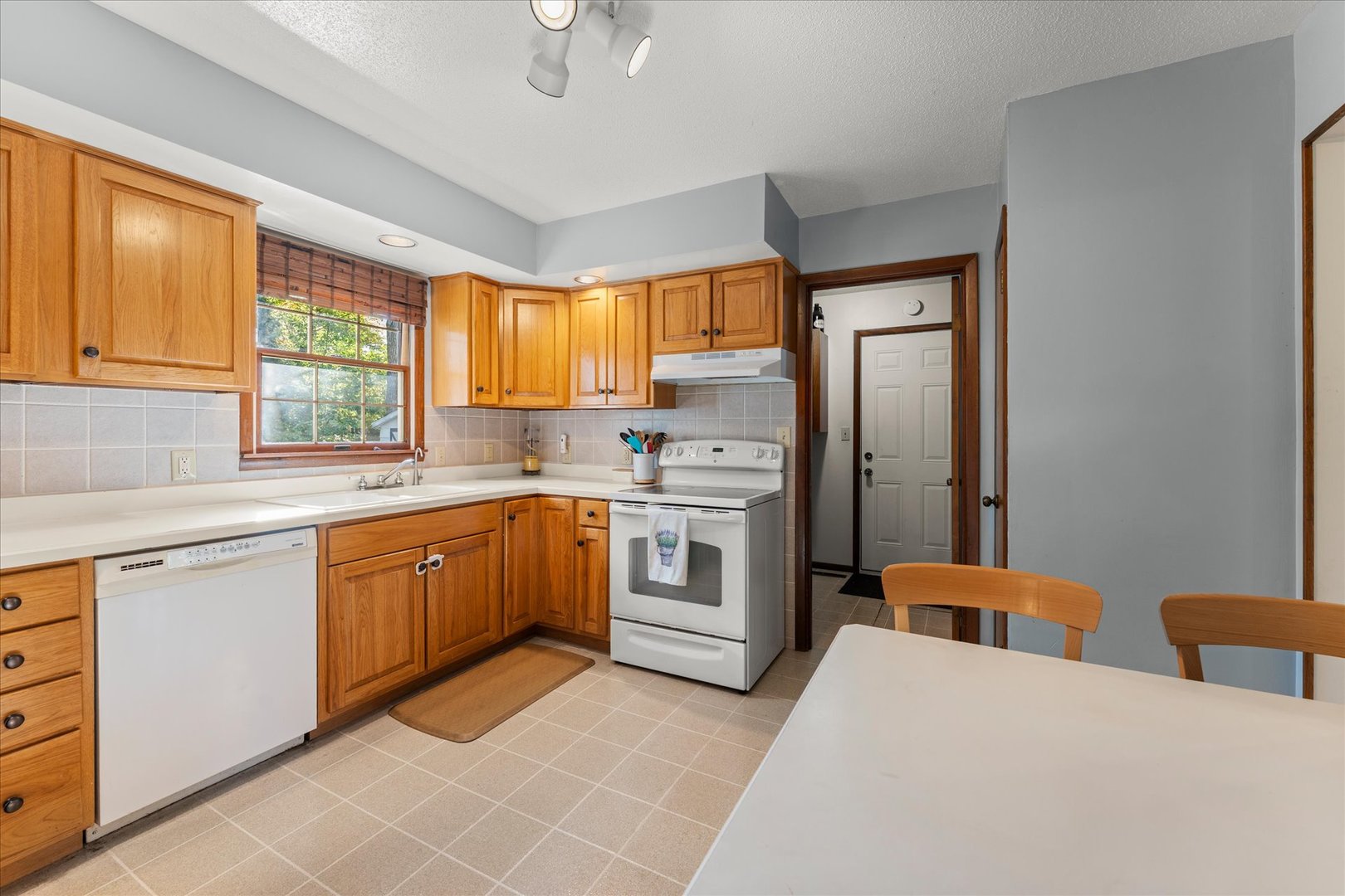1108 Riverside Court Mahomet, IL 61853 - Photo 12 of 50 a kitchen with stainless steel appliances granite countertop a stove a sink dishwasher a refrigerator and a dining table with wooden cabinet