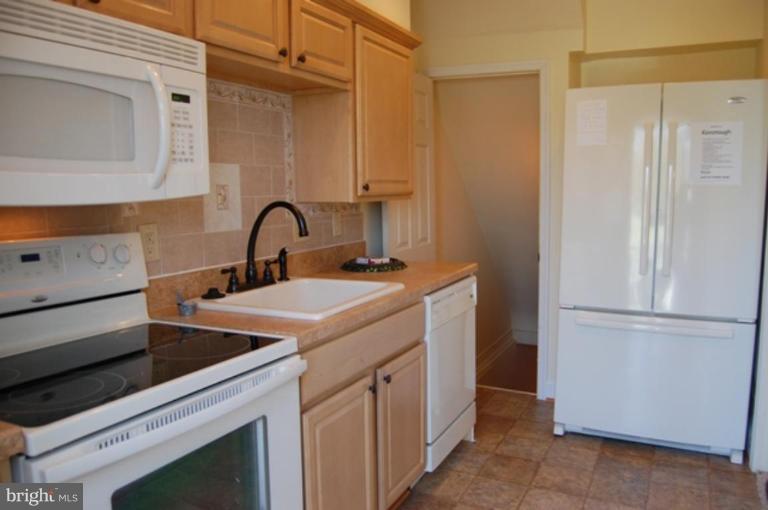 7942 Kavanagh Road Dundalk, MD 21222 - Photo 9 of 11 a kitchen with stainless steel appliances granite countertop a sink stove and refrigerator