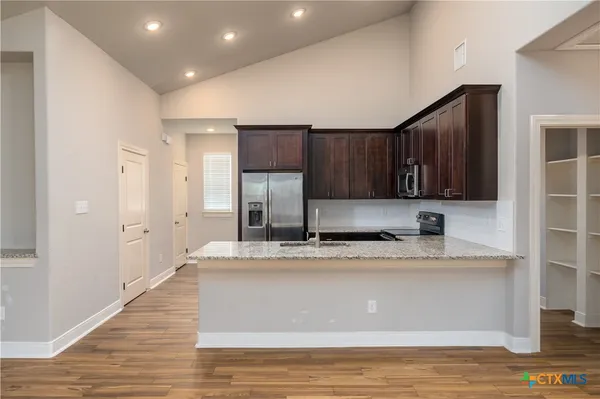 a view of a kitchen with wooden floor and a ceiling fan