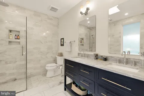 a bathroom with a granite countertop sink mirror and toilet
