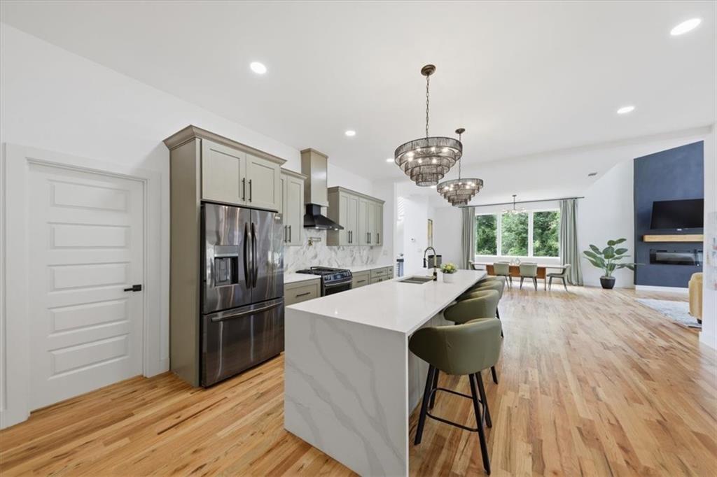 4107 Danforth Road Southwest Atlanta, GA 30331 - Photo 19 of 64 a kitchen with stainless steel appliances kitchen island granite countertop a refrigerator stove and wooden floor