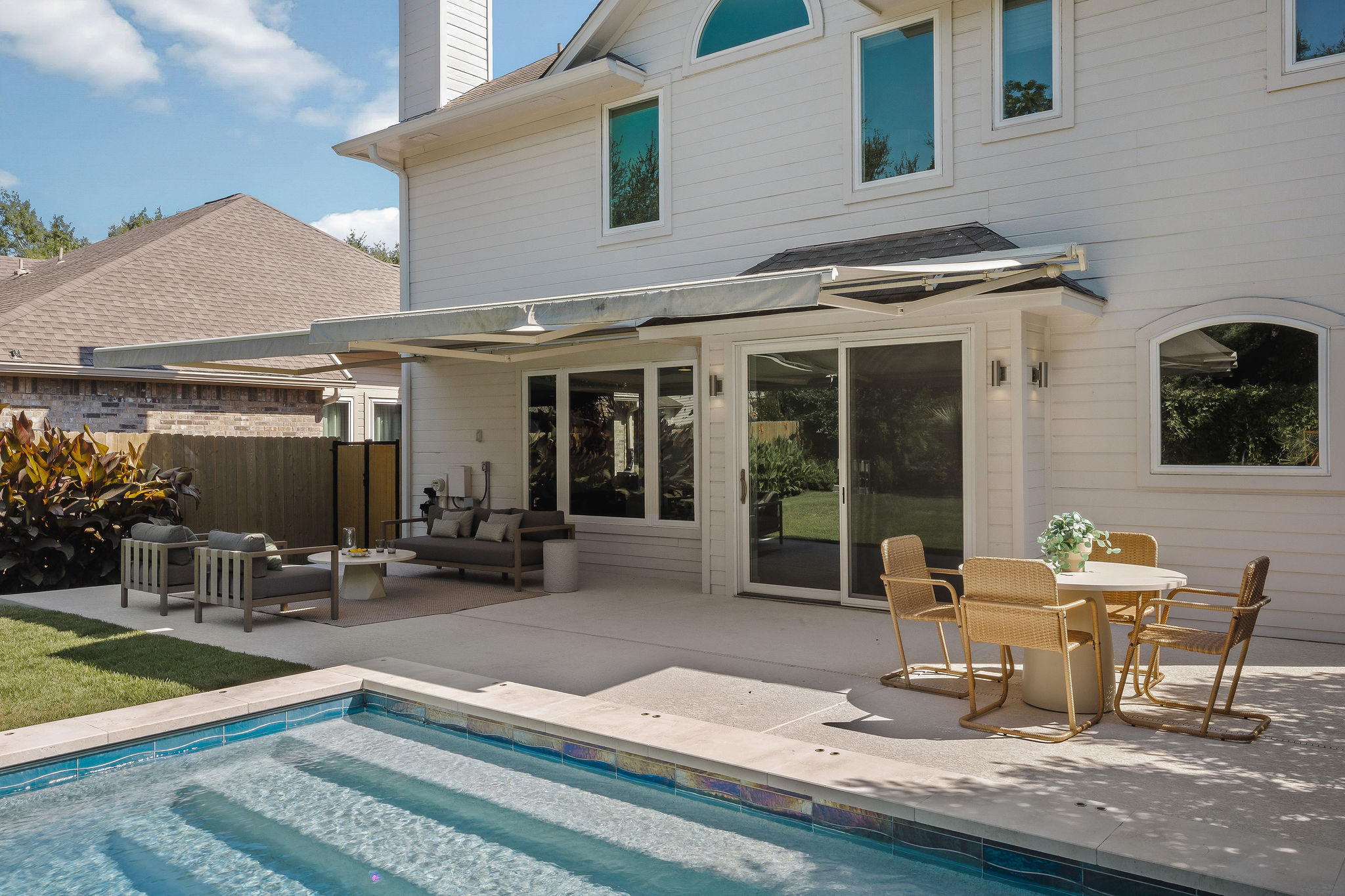 6500 Clay Allison Pass Austin, TX 78749 - Photo 36 of 39 Outdoor living space featuring a rectangular pool with tiled accents and steps, a concrete patio, and a retractable awning