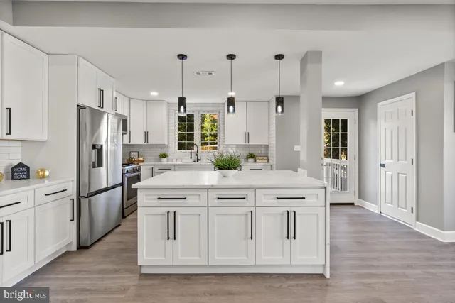 a kitchen with stainless steel appliances kitchen island granite countertop a refrigerator and a stove