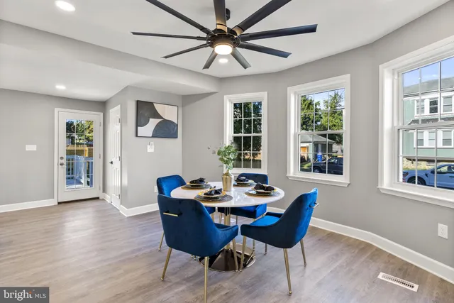 a dining room with furniture a chandelier and wooden floor