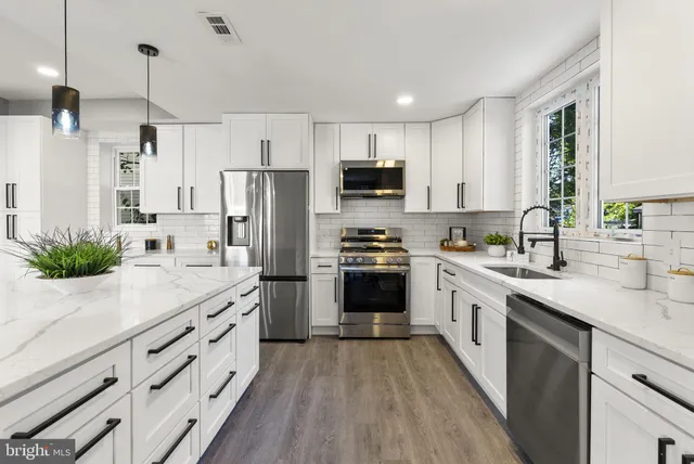 a kitchen with stainless steel appliances granite countertop a sink and a stove top oven