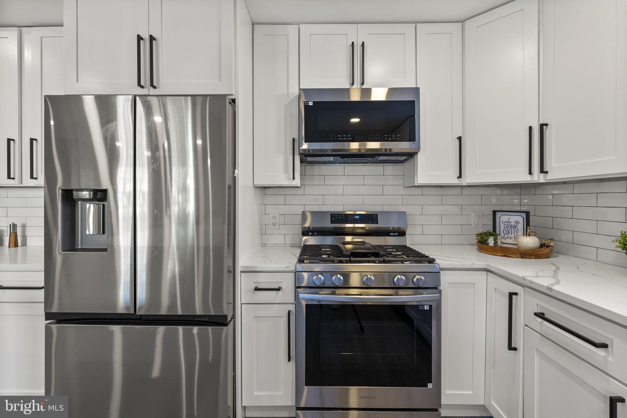 3417 Springdale Avenue Baltimore, MD 21216 - Photo 18 of 60 a kitchen with stainless steel appliances a stove a refrigerator and cabinets