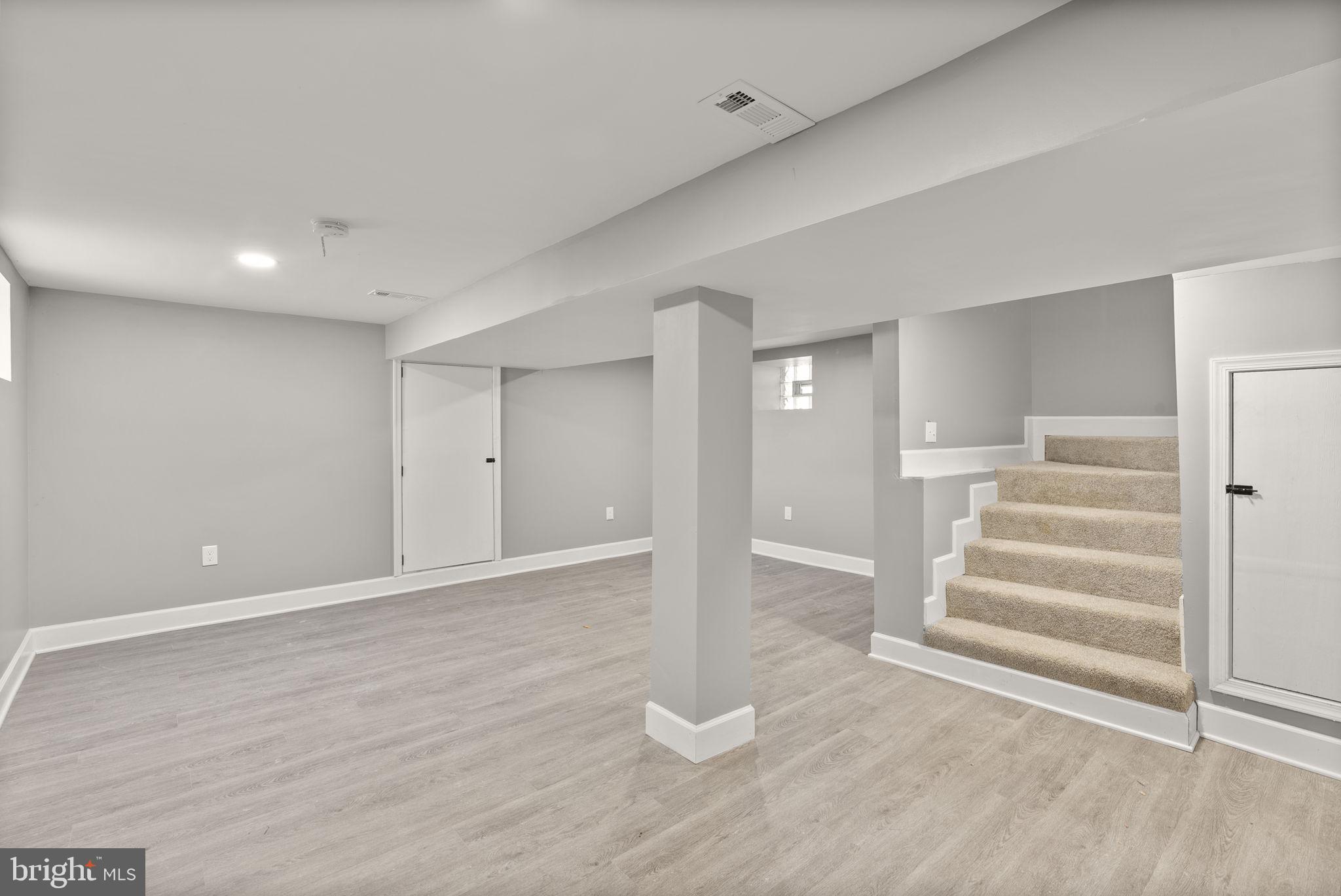 3417 Springdale Avenue Baltimore, MD 21216 - Photo 21 of 60 a view of an empty room with wooden floor and stairs