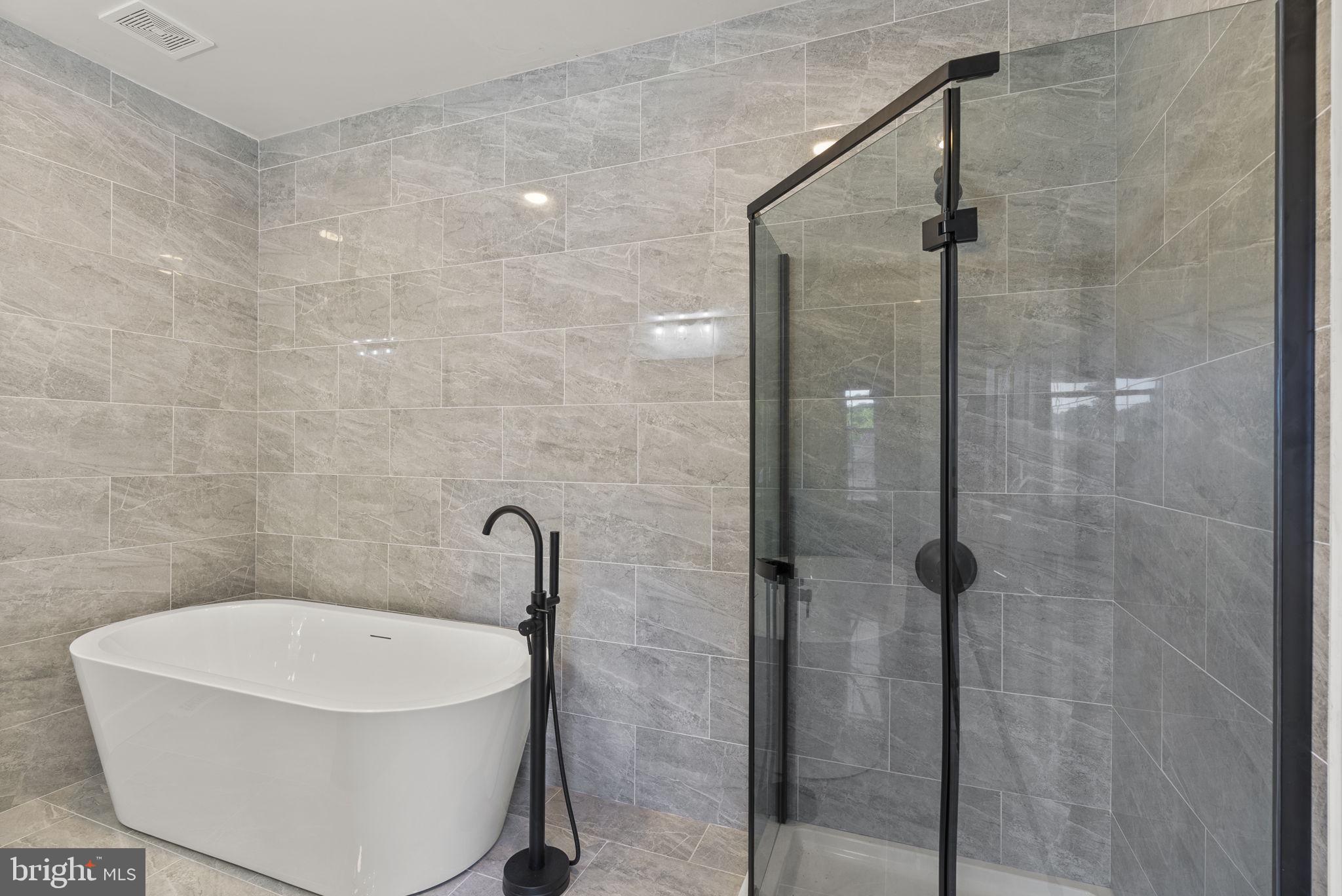 3417 Springdale Avenue Baltimore, MD 21216 - Photo 35 of 60 a bath tub sitting next to a white sink and a shower