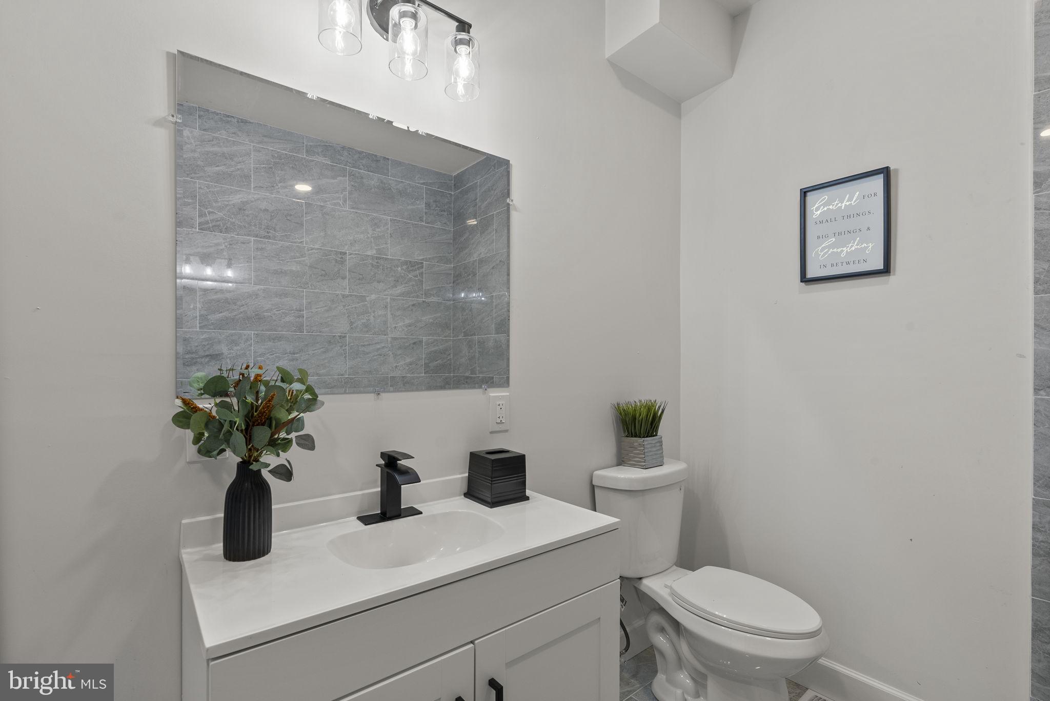 3417 Springdale Avenue Baltimore, MD 21216 - Photo 37 of 60 a bathroom with a sink a toilet and a mirror
