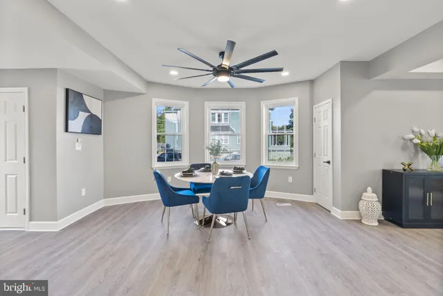 a dining room with furniture a chandelier and wooden floor