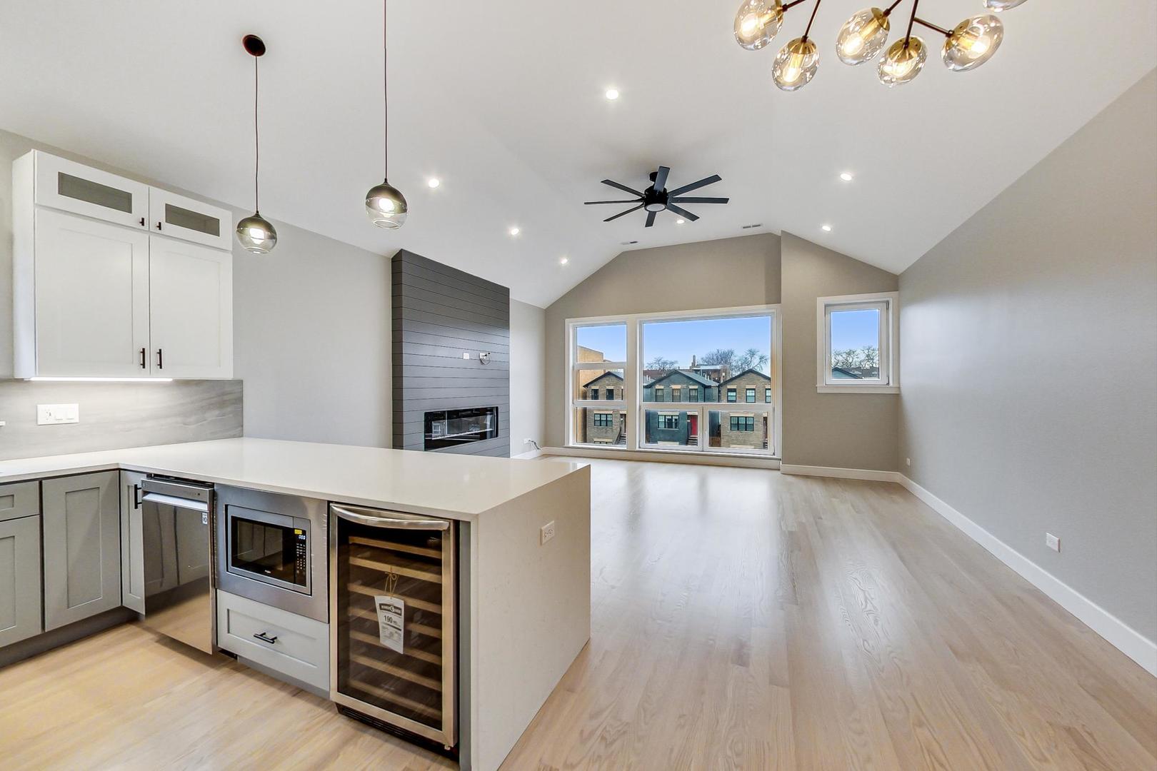 4745 South Indiana Avenue, Unit 3 Chicago, IL 60615 - Photo 26 of 42 a large kitchen with stainless steel appliances a large counter top a stove and a wooden floors