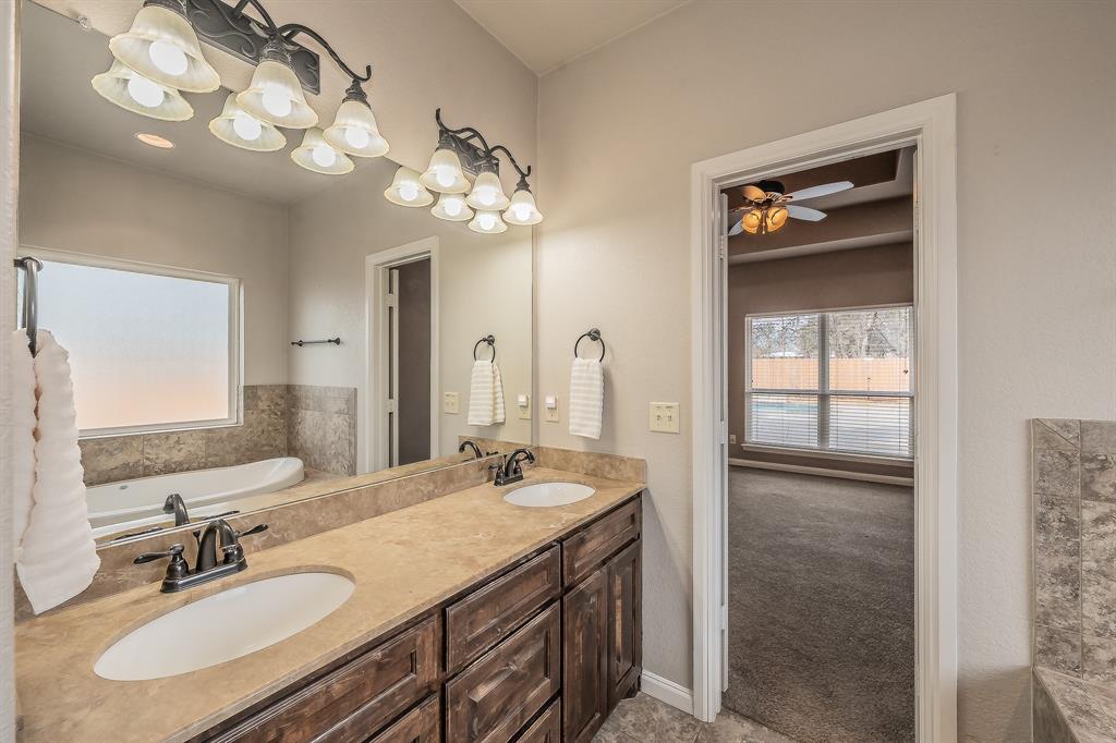 405 Edgewood Terrace Boyd, TX 76023 - Photo 17 of 39 a bathroom with a double vanity sink and a mirror