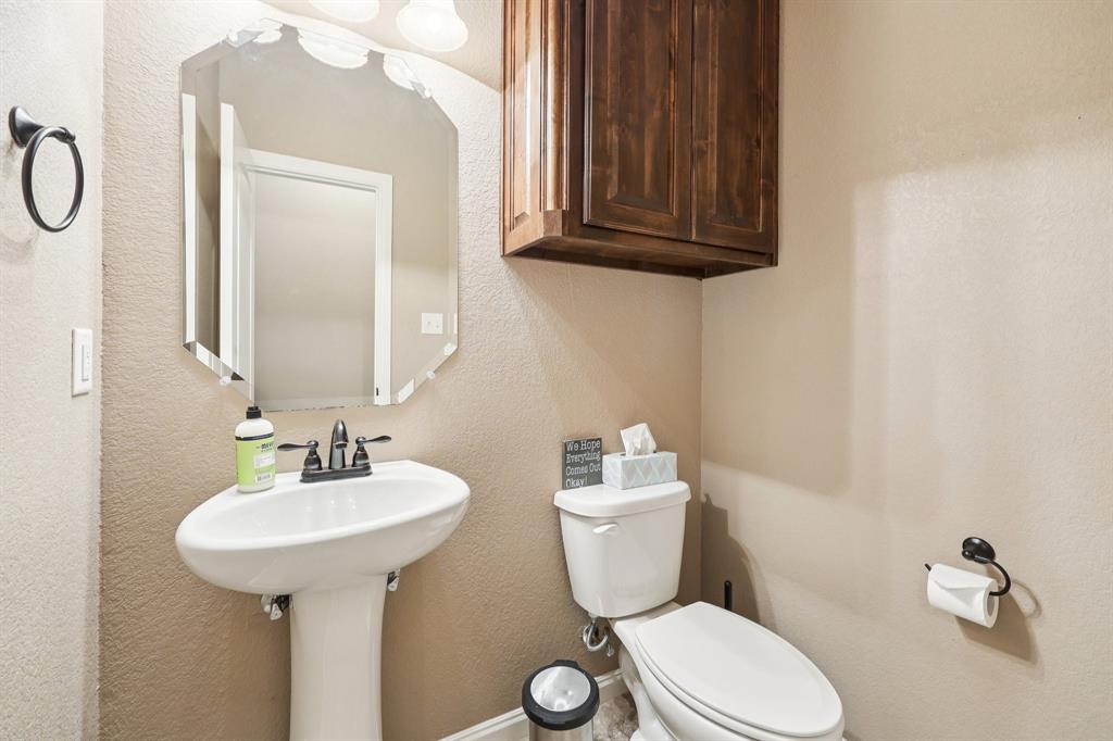 405 Edgewood Terrace Boyd, TX 76023 - Photo 22 of 39 a bathroom with a toilet sink and mirror