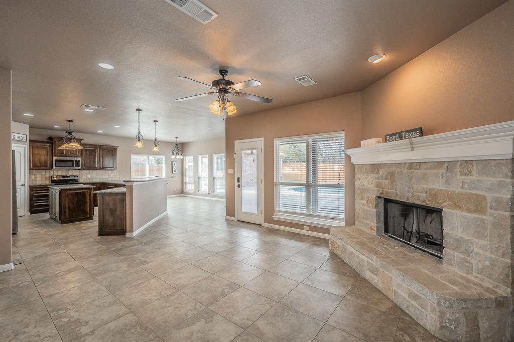 405 Edgewood Terrace Boyd, TX 76023 - Photo 5 of 39 a view of a kitchen with a stove cabinets and a fireplace