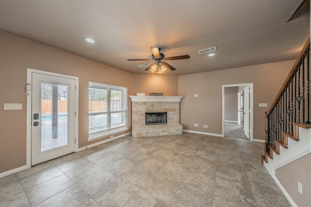 405 Edgewood Terrace Boyd, TX 76023 - Photo 7 of 39 a view of an empty room with a fireplace and a window