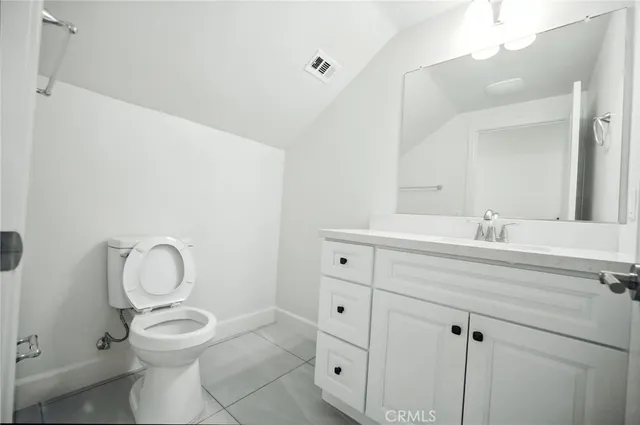a bathroom with a toilet sink vanity and mirror
