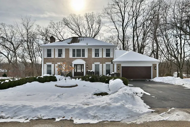 a front view of a house with yard covered in snow