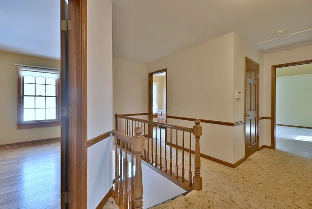 an empty room with windows and fireplace