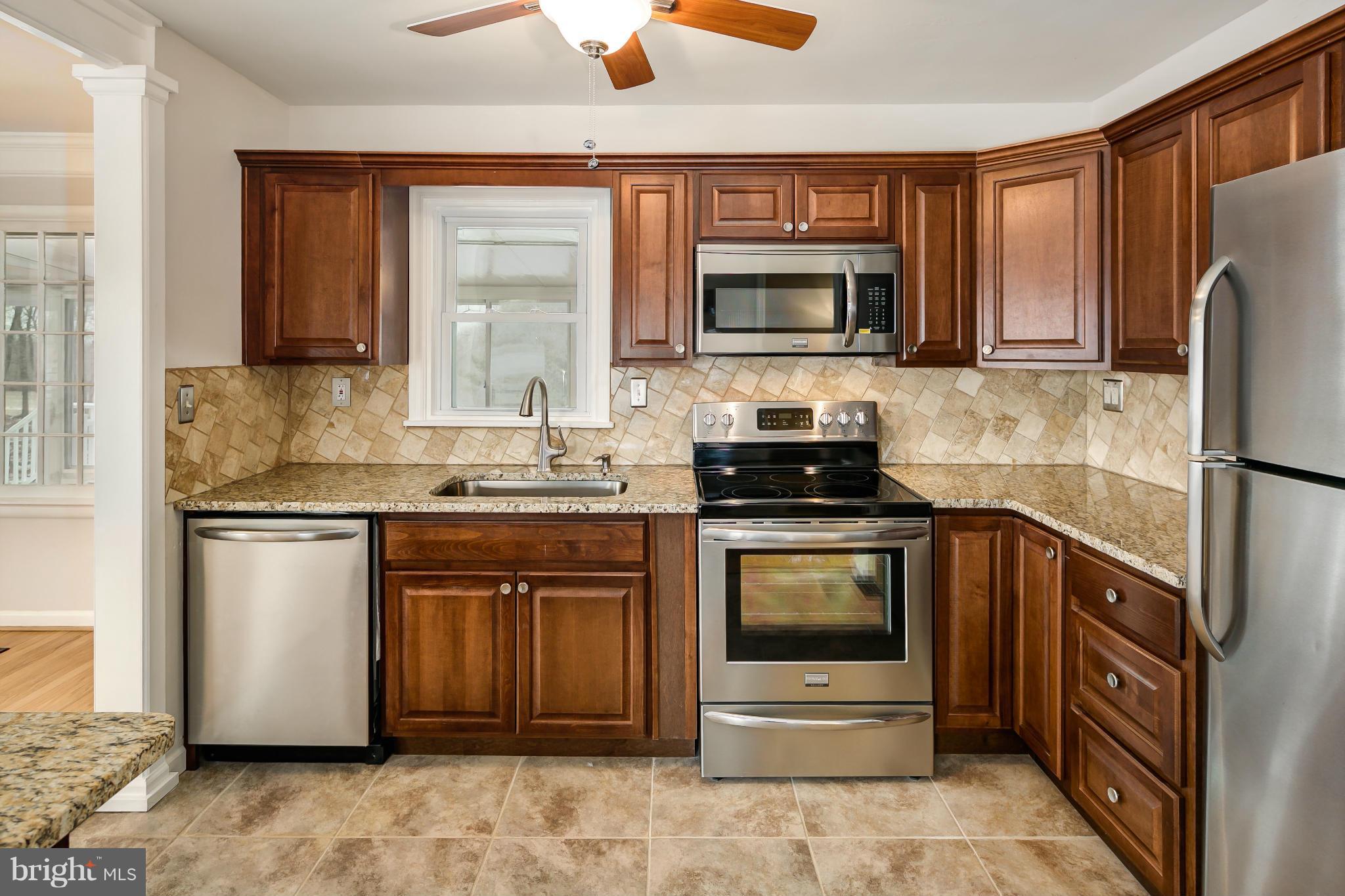 27110 Ridge Road Damascus, MD 20872 - Photo 3 of 30 a kitchen with stainless steel appliances granite countertop a refrigerator stove and sink