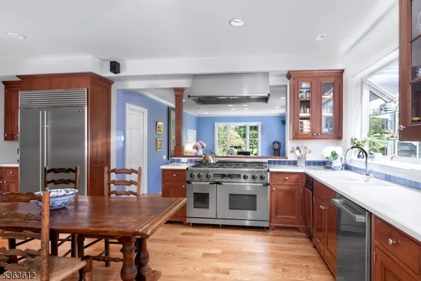a kitchen with stainless steel appliances granite countertop a stove top oven a sink dishwasher a dining table and chairs