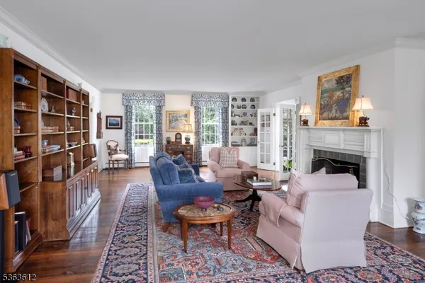 a living room with furniture a fireplace and a book shelf