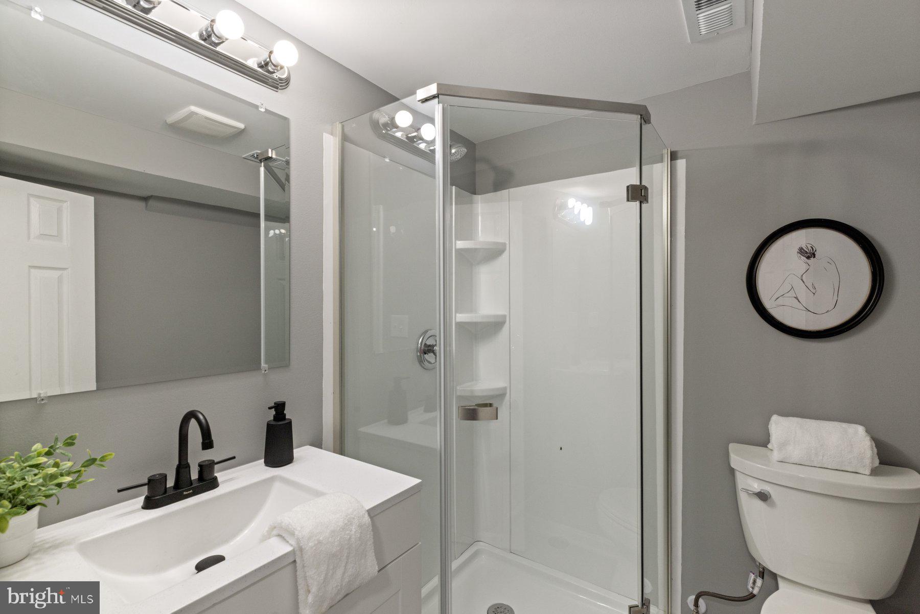 1579 Dellsway Road Towson, MD 21286 - Photo 21 of 33 a bathroom with a toilet a sink a mirror a vanity and shower