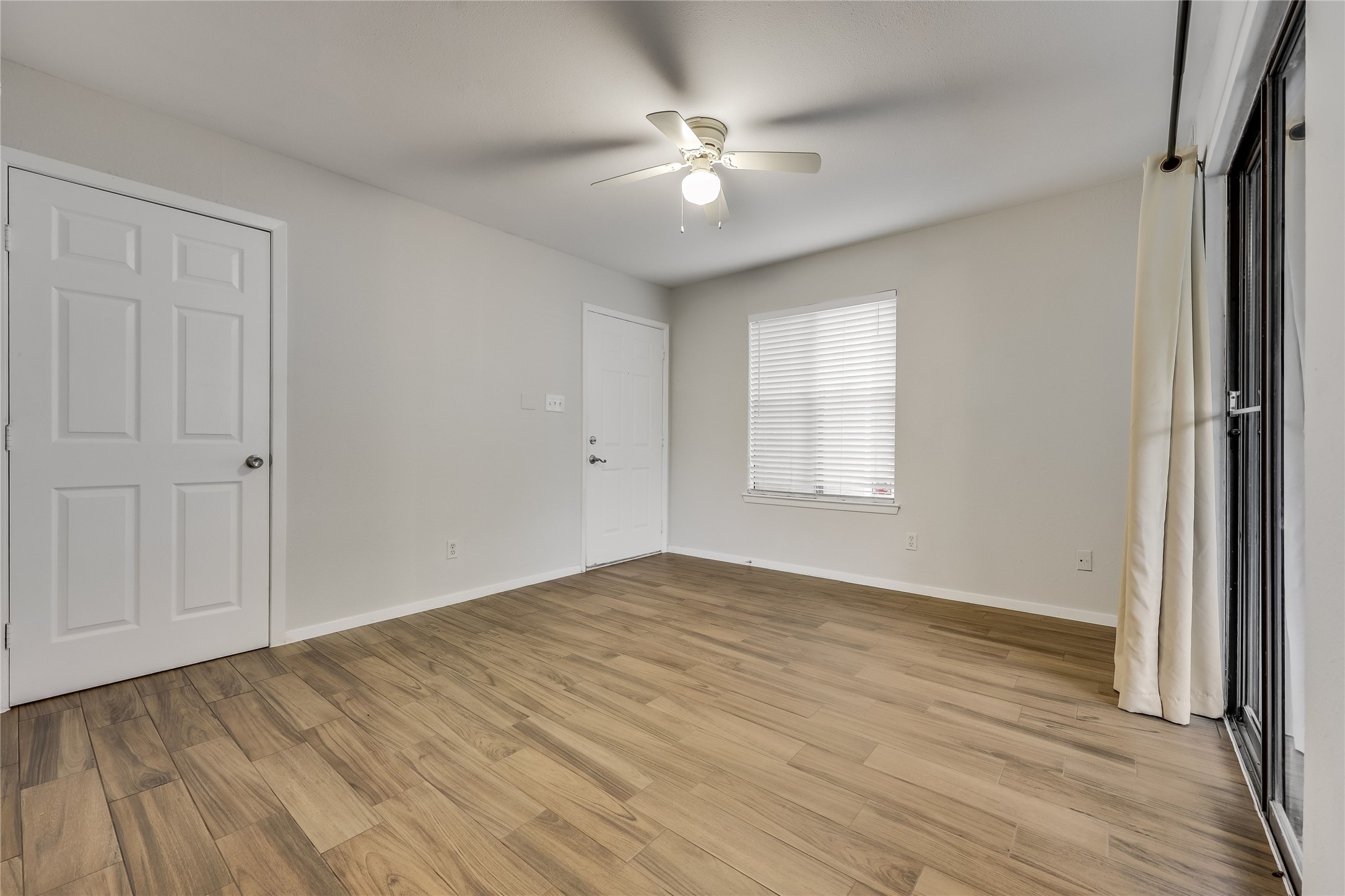 2500 Burleson Road, Unit 609 Austin, TX 78741 - Photo 15 of 32 Well-lit room features durable wood-look flooring and convenient sliding door access to outdoor space.