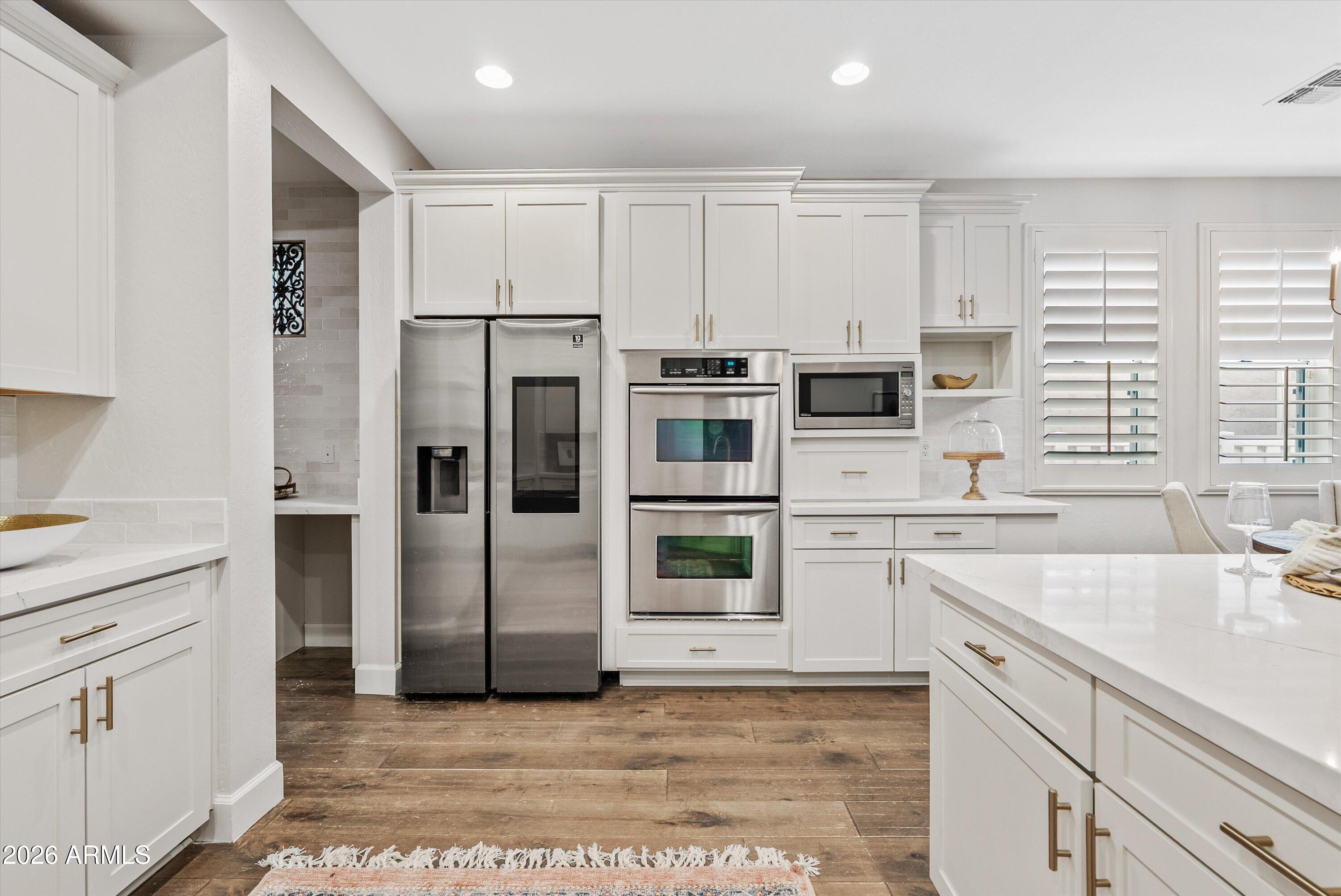 3112 East Agritopia Loop North Gilbert, AZ 85296 - Photo 12 of 40 a kitchen with stainless steel appliances a refrigerator sink and cabinets