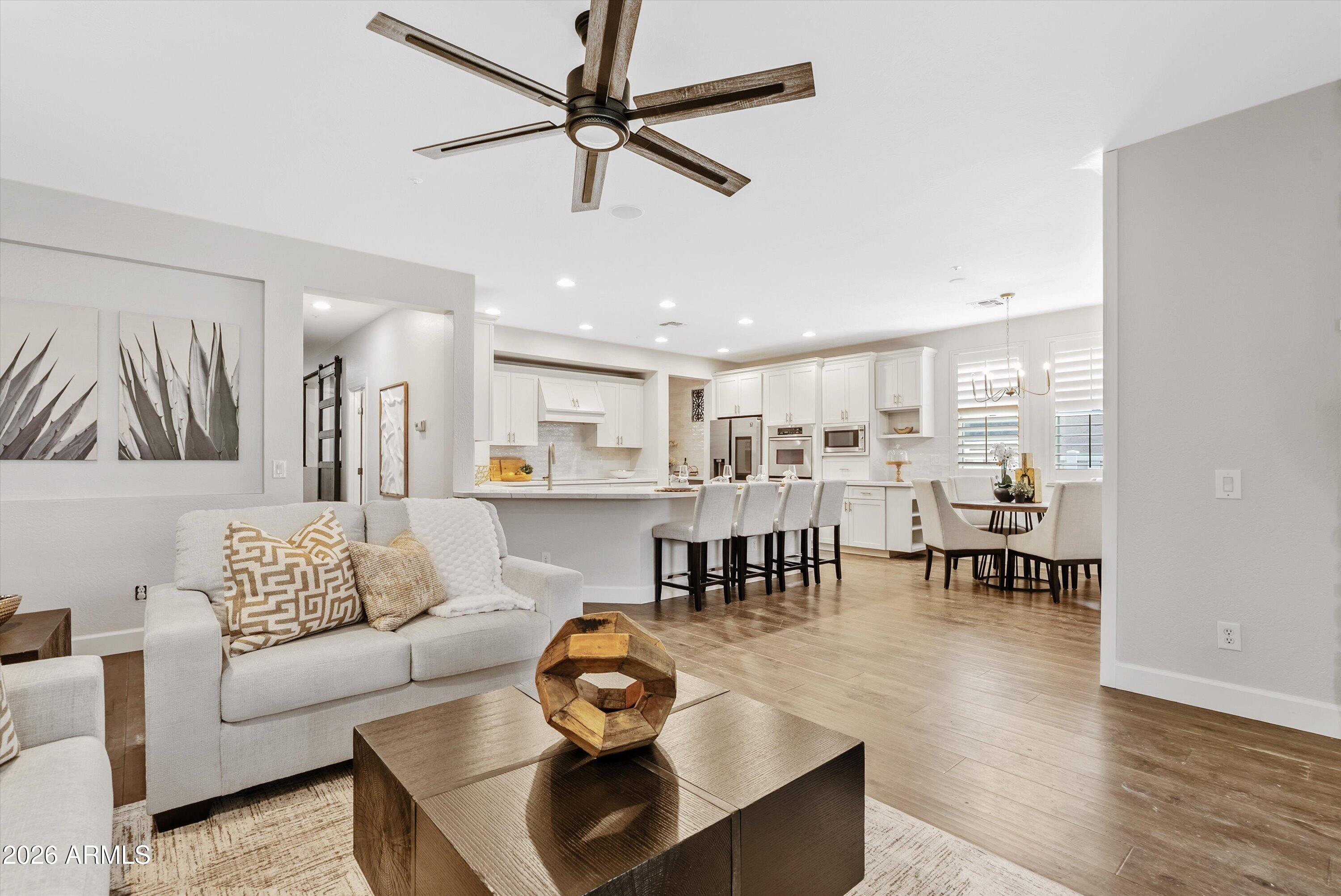 3112 East Agritopia Loop North Gilbert, AZ 85296 - Photo 18 of 40 a living room with furniture kitchen view and a wooden floor