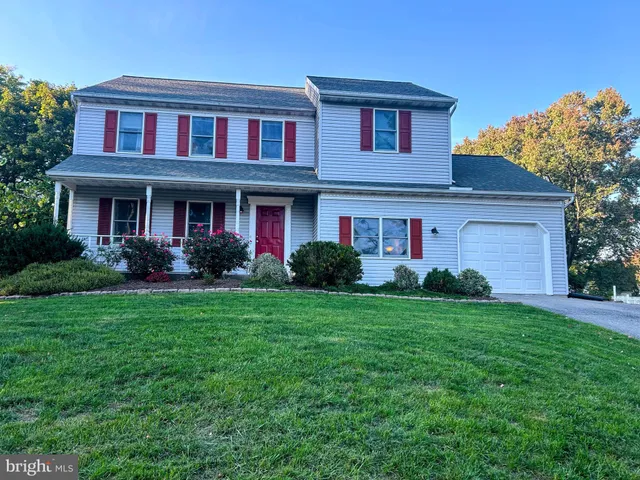 a front view of a house with porch and garden