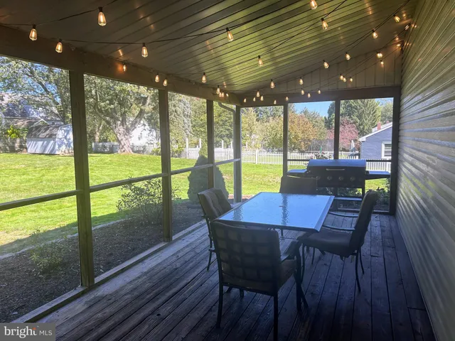 a view of a porch with furniture and wooden floor