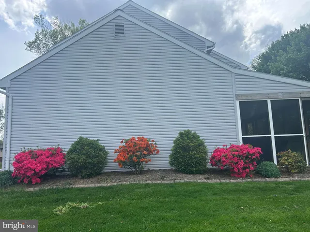 a small white house with a yard and a table