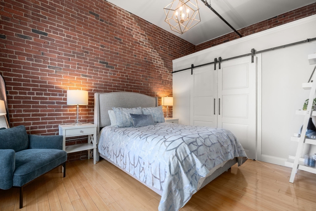 35 Channel Center Street, Unit 303 Boston, MA 02210 - Photo 12 of 28 a bedroom with a bed couch and a window
