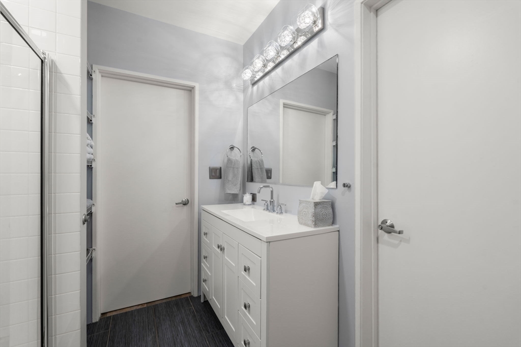 35 Channel Center Street, Unit 303 Boston, MA 02210 - Photo 21 of 28 a bathroom with a sink a mirror and a vanity