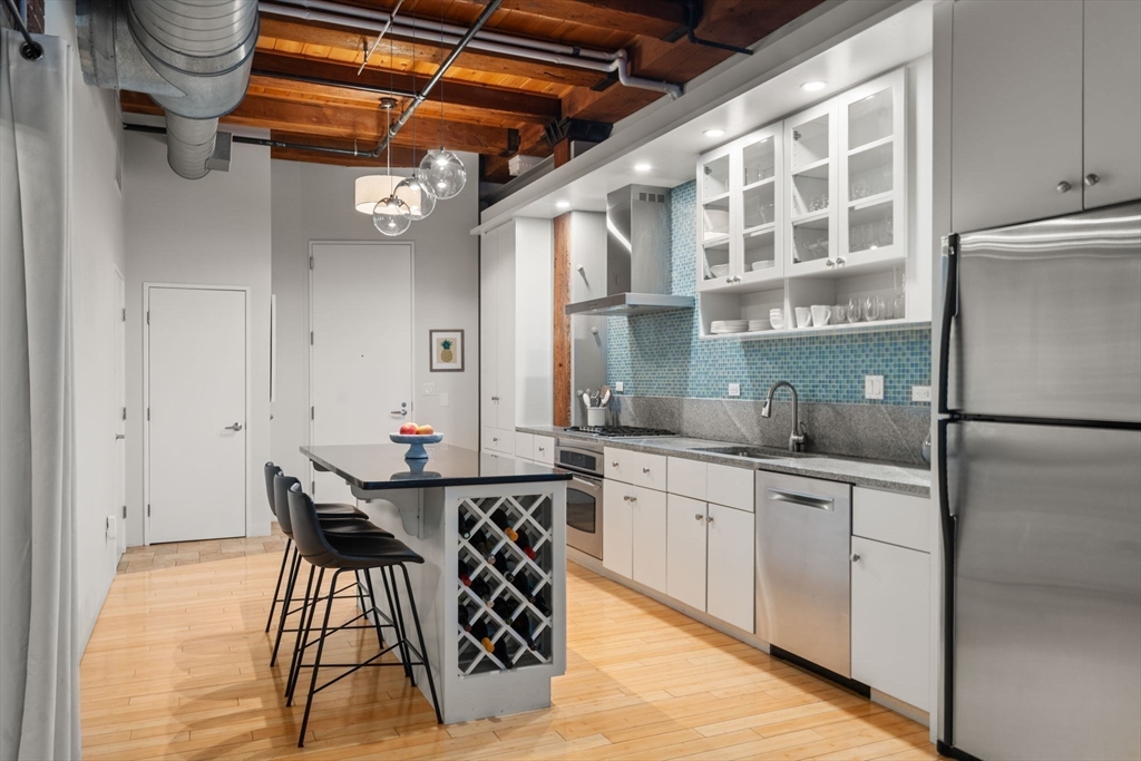 35 Channel Center Street, Unit 303 Boston, MA 02210 - Photo 3 of 28 a kitchen with stainless steel appliances granite countertop a sink and cabinets