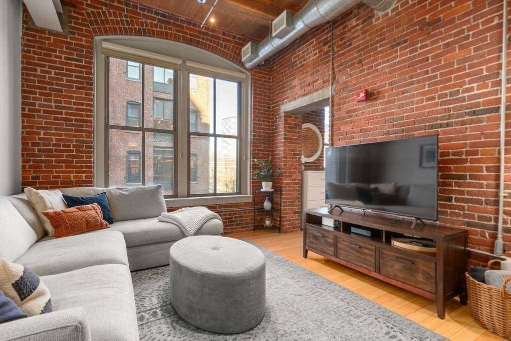 35 Channel Center Street, Unit 303 Boston, MA 02210 - Photo 8 of 28 a living room with furniture and a flat screen tv