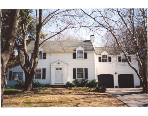 a view of a white house with a large tree