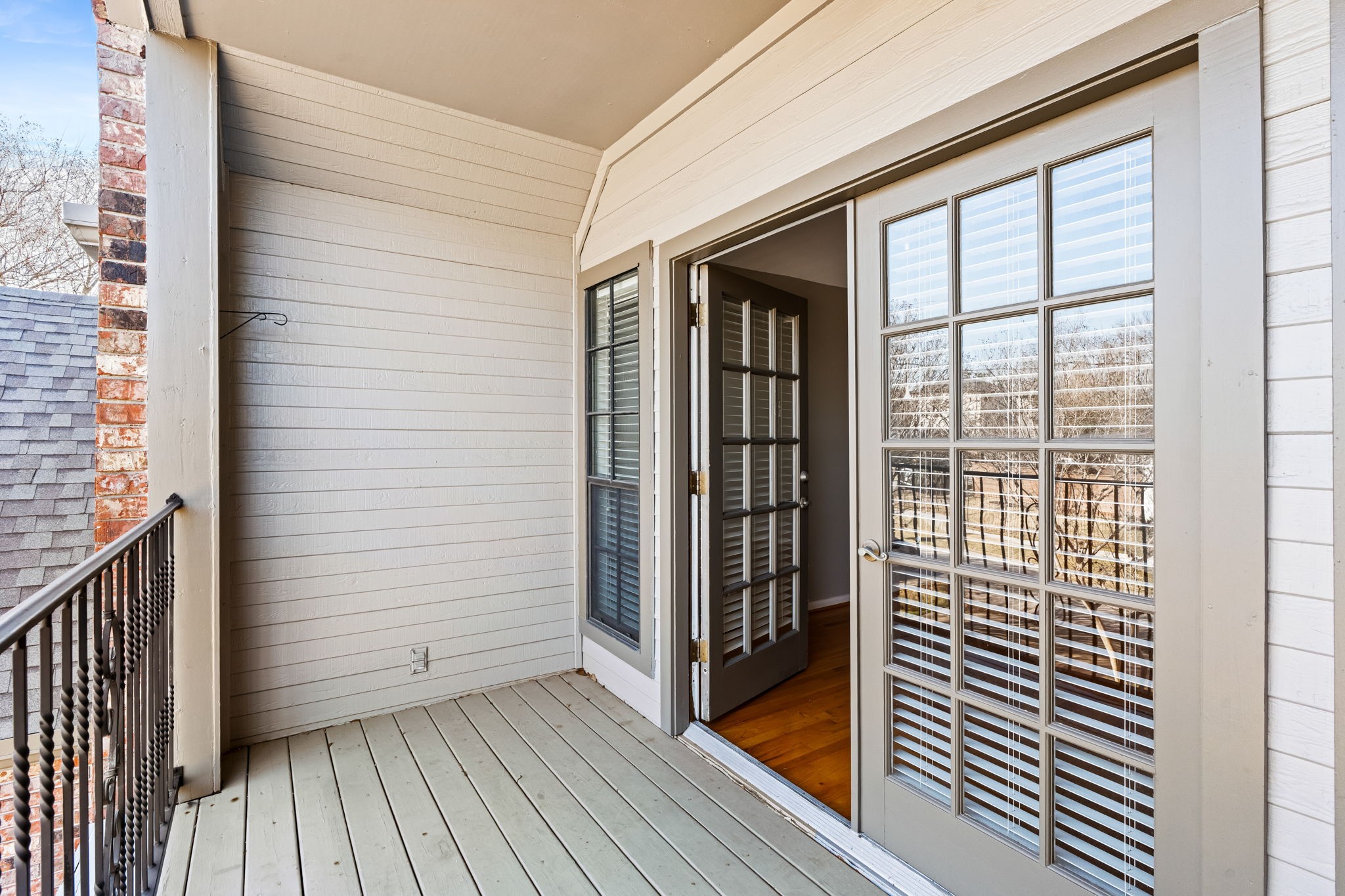 254 East 5th Street Houston, TX 77007 - Photo 14 of 31 Step outside to a covered private balcony overlooking the tree-lined surroundings. An ideal extension of the primary bedroom, this elevated outdoor space offers a peaceful setting for morning coffee or evening relaxation.