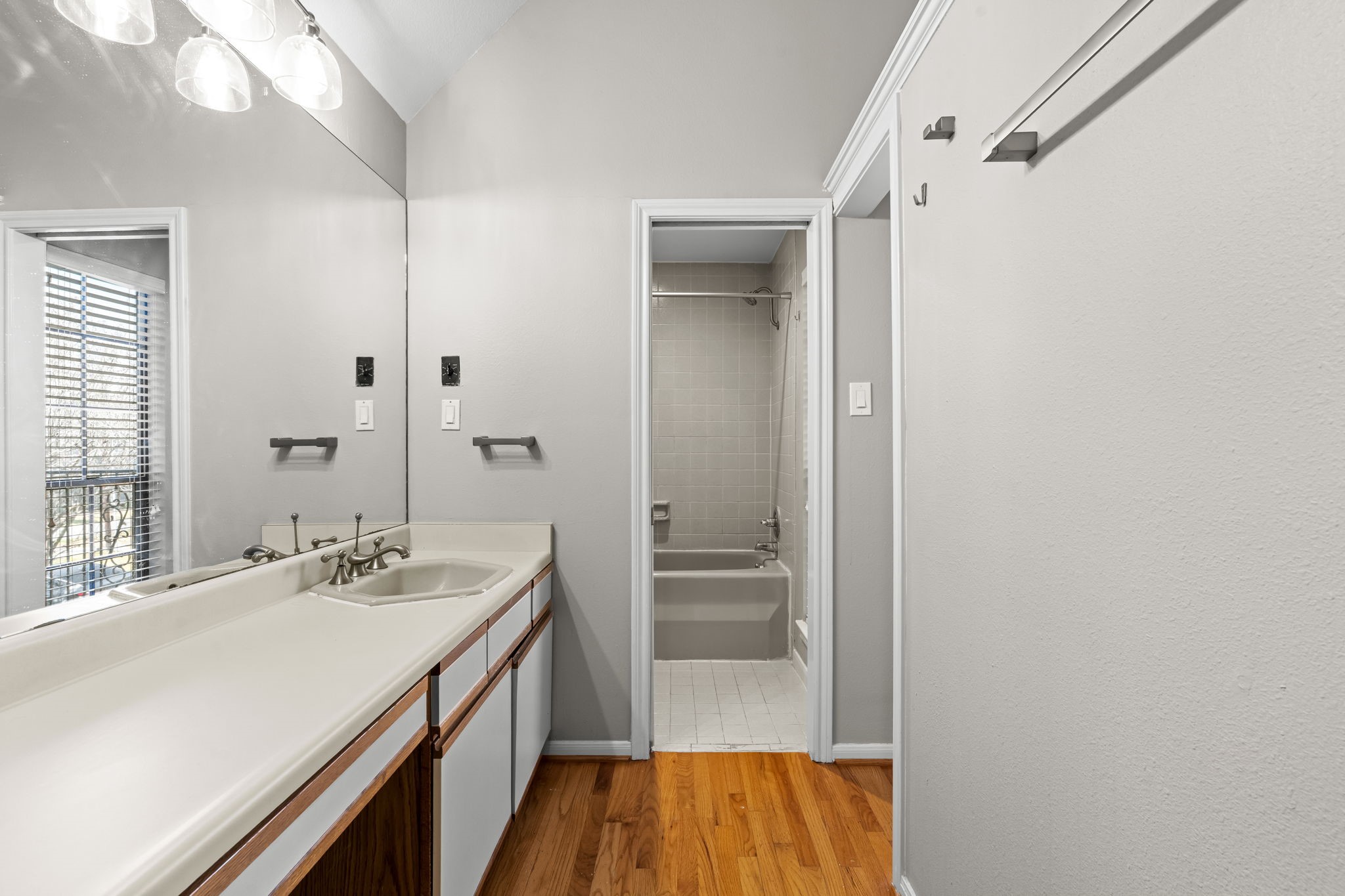 254 East 5th Street Houston, TX 77007 - Photo 15 of 31 The primary bath includes a full tub and shower combination with a clean, functional layout. Generous counter space and natural light enhance the overall comfort and usability of the space.
