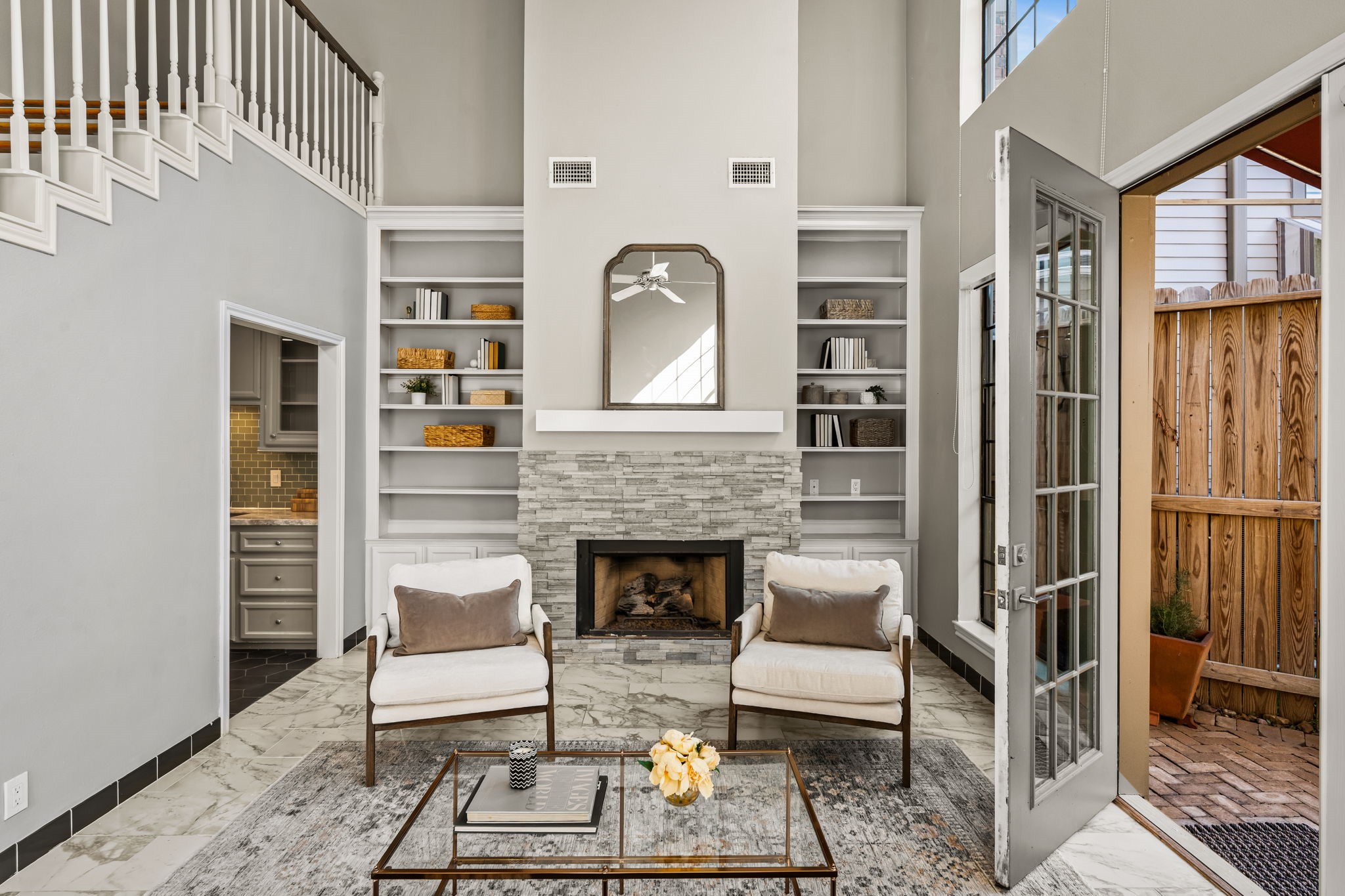 254 East 5th Street Houston, TX 77007 - Photo 6 of 31 A striking fireplace anchors the space, flanked by built-in shelving for added functionality and design symmetry. The expansive wall height emphasizes the home’s airy and open feel.