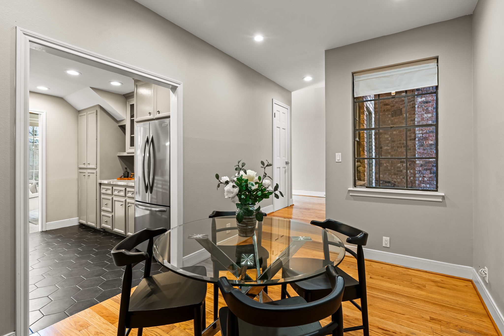 254 East 5th Street Houston, TX 77007 - Photo 8 of 31 Positioned just off the kitchen, the formal dining space features hardwood floors and recessed lighting that define the area without closing it off. Its placement enhances the natural flow of the first-floor layout, making hosting effortless.