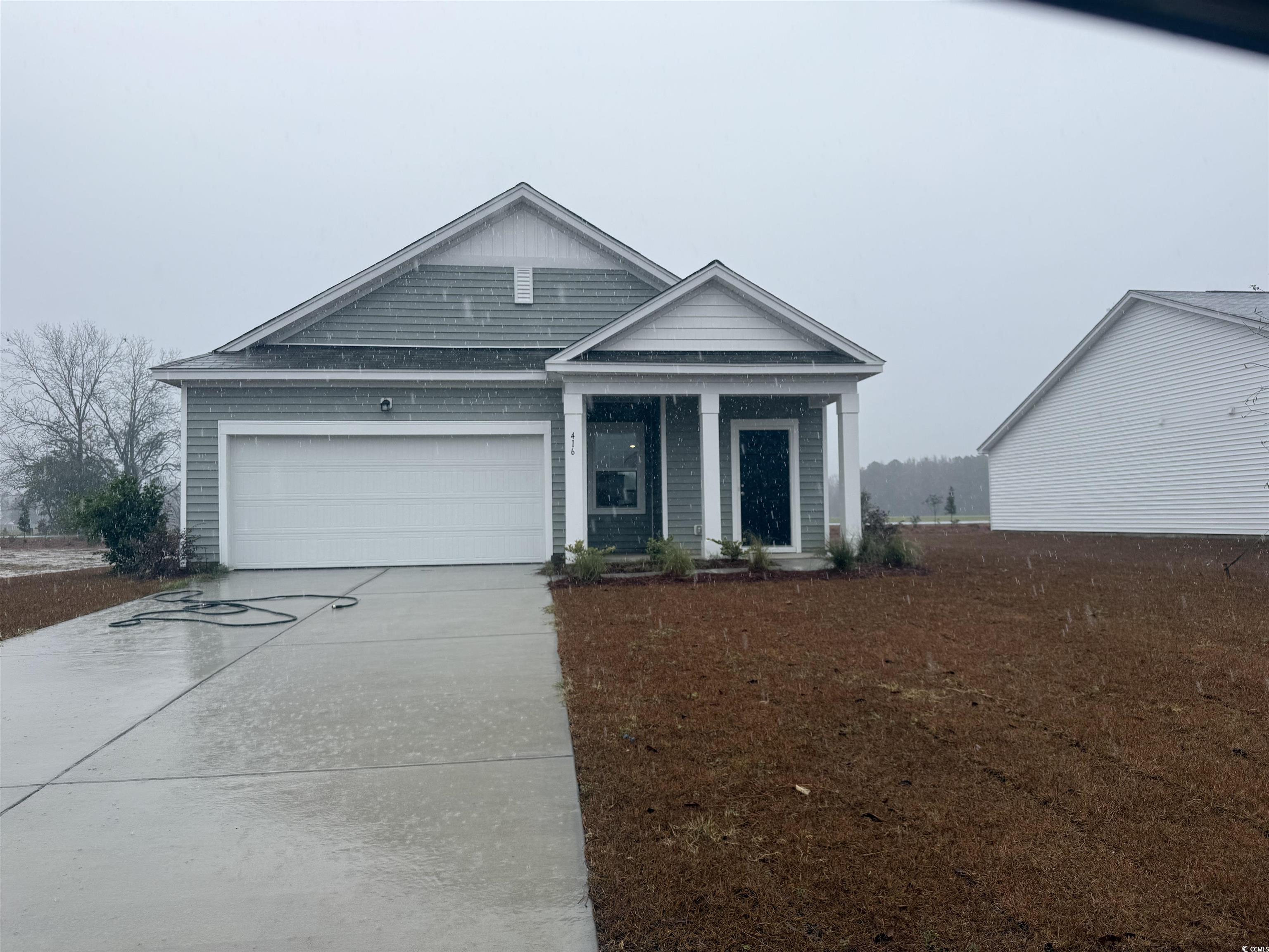 View of front facade with concrete driveway and a garage